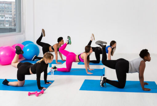females on a mat doing barre poses